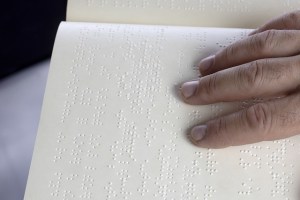 Hand moving over a Braille book