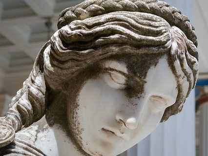 A female statue staring with head turned