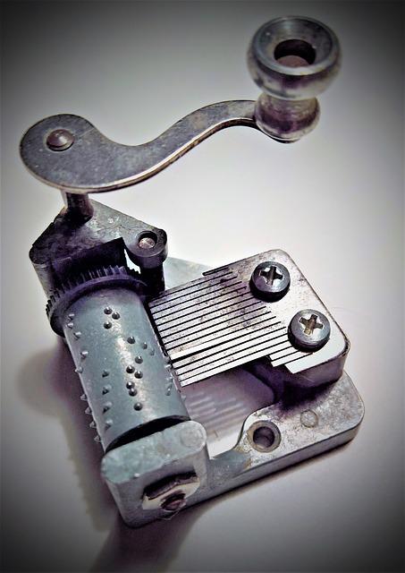 Workings of a music box with bumps on a barrel flicking metal prongs