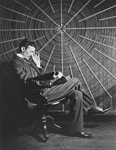 Nikola Tesla in front of a giant coil