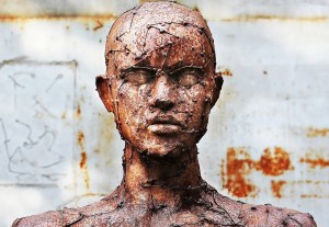 A bronze statue showing head and shoulders with a very textured face
