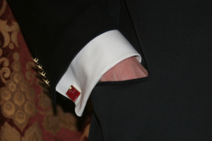 A hand in a pocket of a formal jacket with cufflink showing.