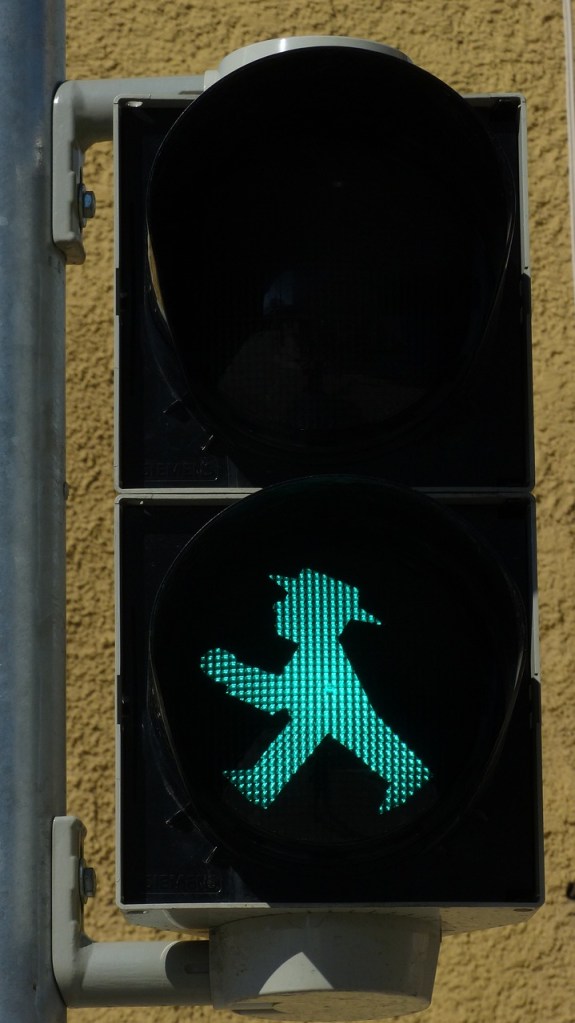 A pedestrian light showing green/walk