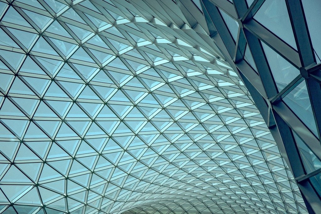 A curving roof made of triangles of glass.