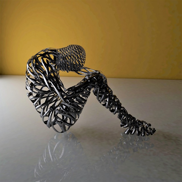 A metal figure sitting on the floor head down