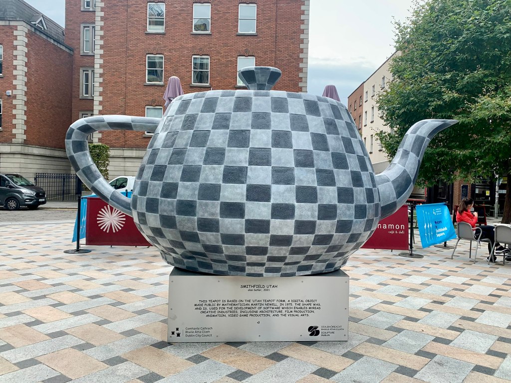 A large sculpture of the Utah teapot, given a dark and light grey chequered pattern.