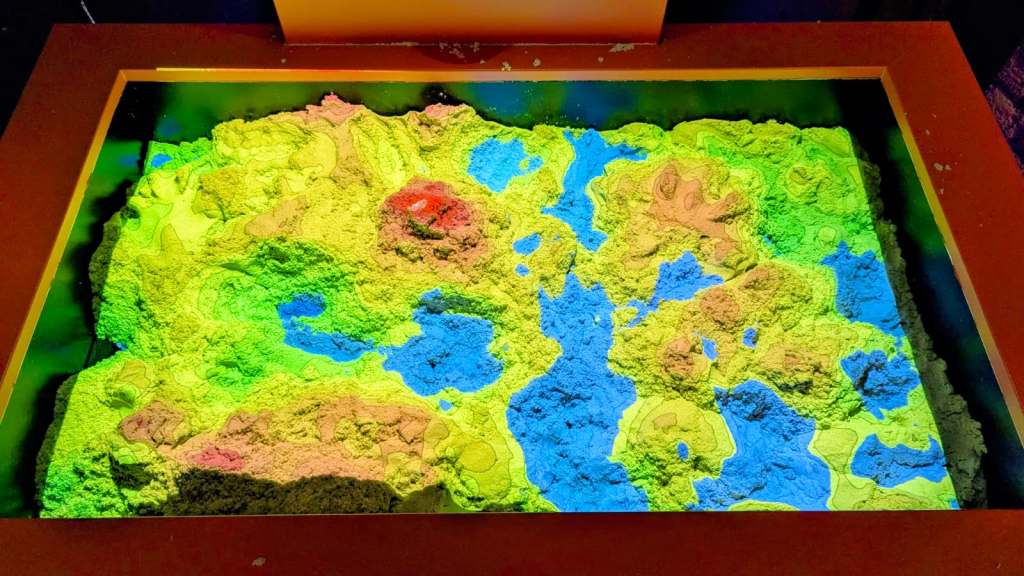 The sand table with colours projected onto it showing height. 